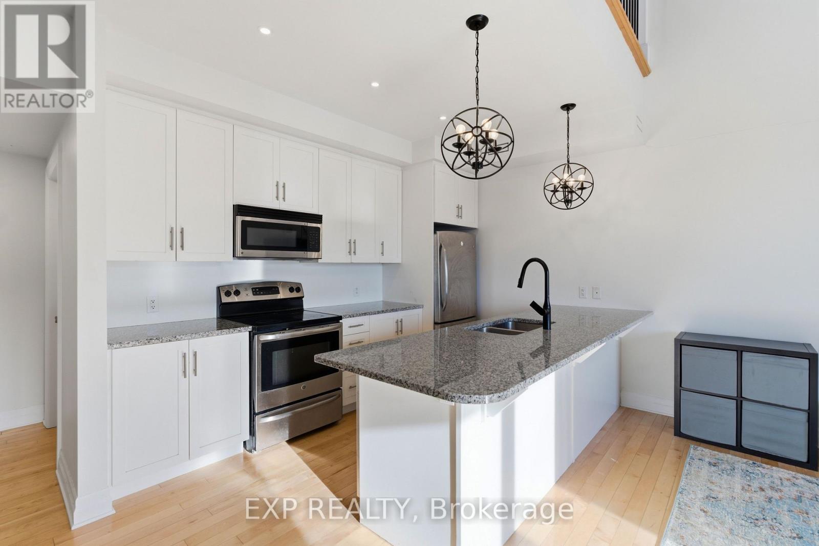A kitchen with white cabinets and a granite countertop.