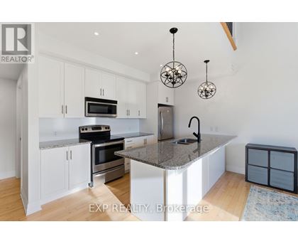 A kitchen with white cabinets and a granite countertop.