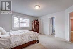 A bedroom with a bed, dresser, and window.