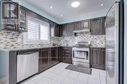 A modern kitchen with dark wood cabinets and a white tiled floor.