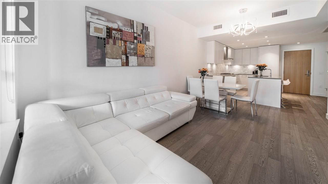 A modern living room with a white sofa and a wooden floor.
