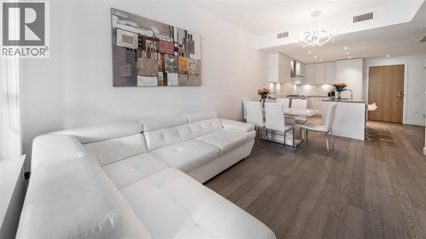 A modern living room with a white sofa and a wooden floor.