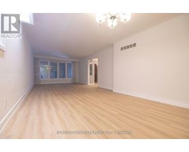 A room with wooden flooring and a chandelier.
