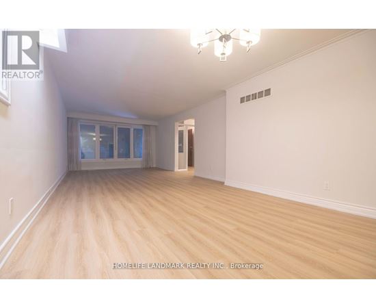 A room with wooden flooring and a chandelier.