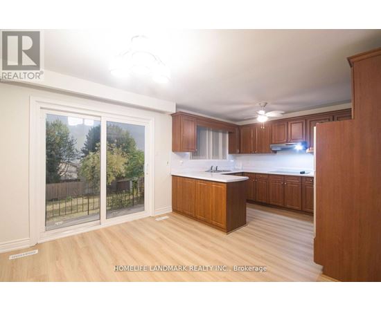 A kitchen with wooden cabinets and a large island in the middle.