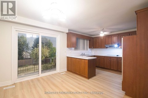 A kitchen with wooden cabinets and a large island in the middle.