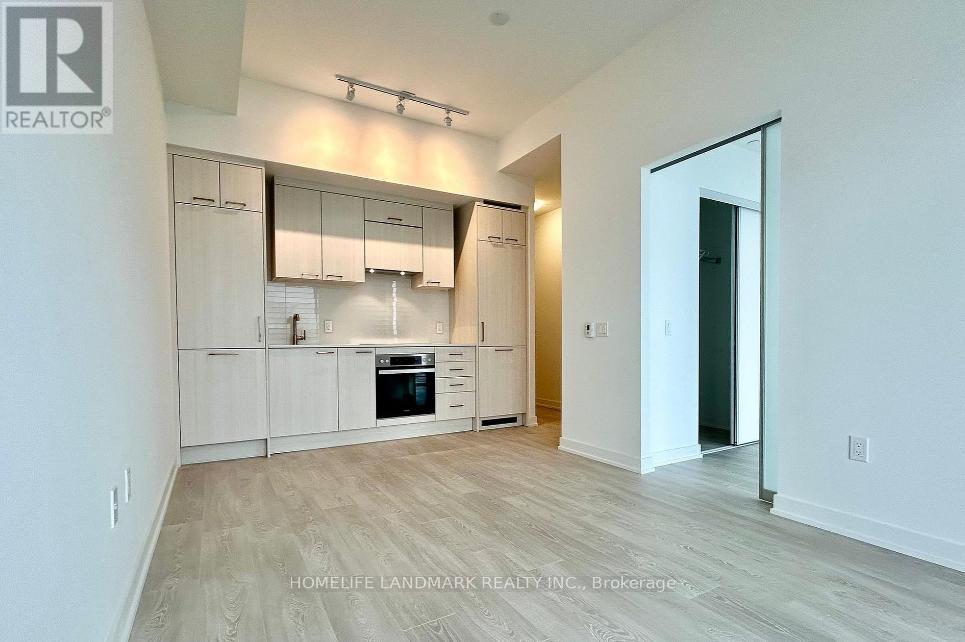 A spacious kitchen with white cabinets and a wooden floor.