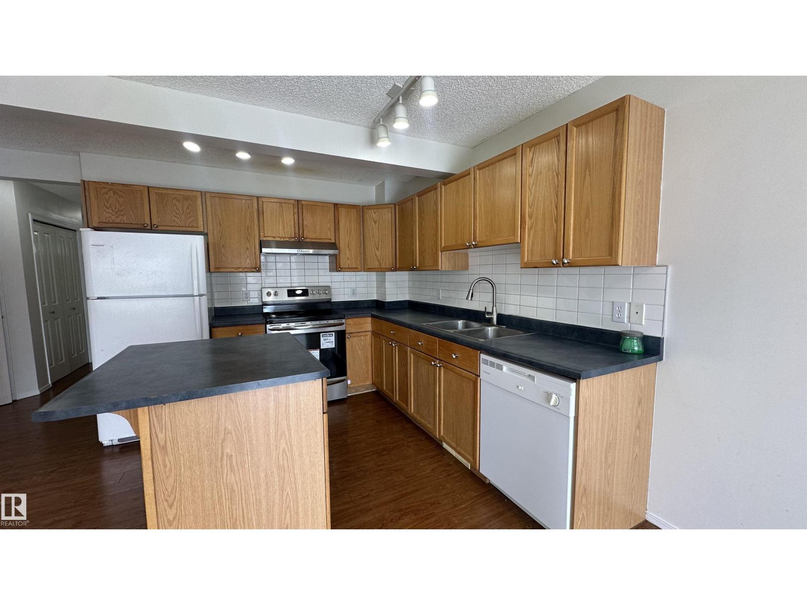 A kitchen with wooden cabinets and a black countertop.