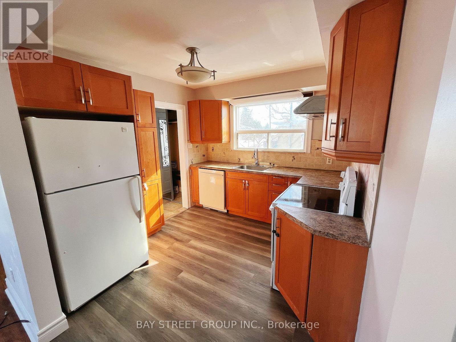A kitchen with wooden cabinets and a white refrigerator.