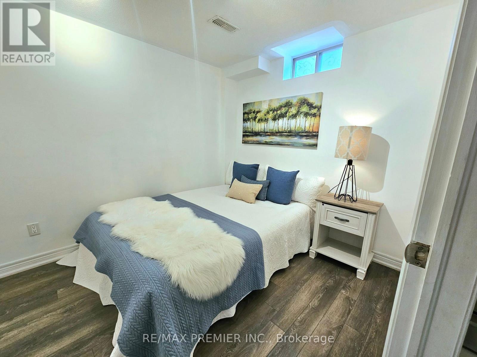 A bedroom with a bed, nightstand, and lamp.