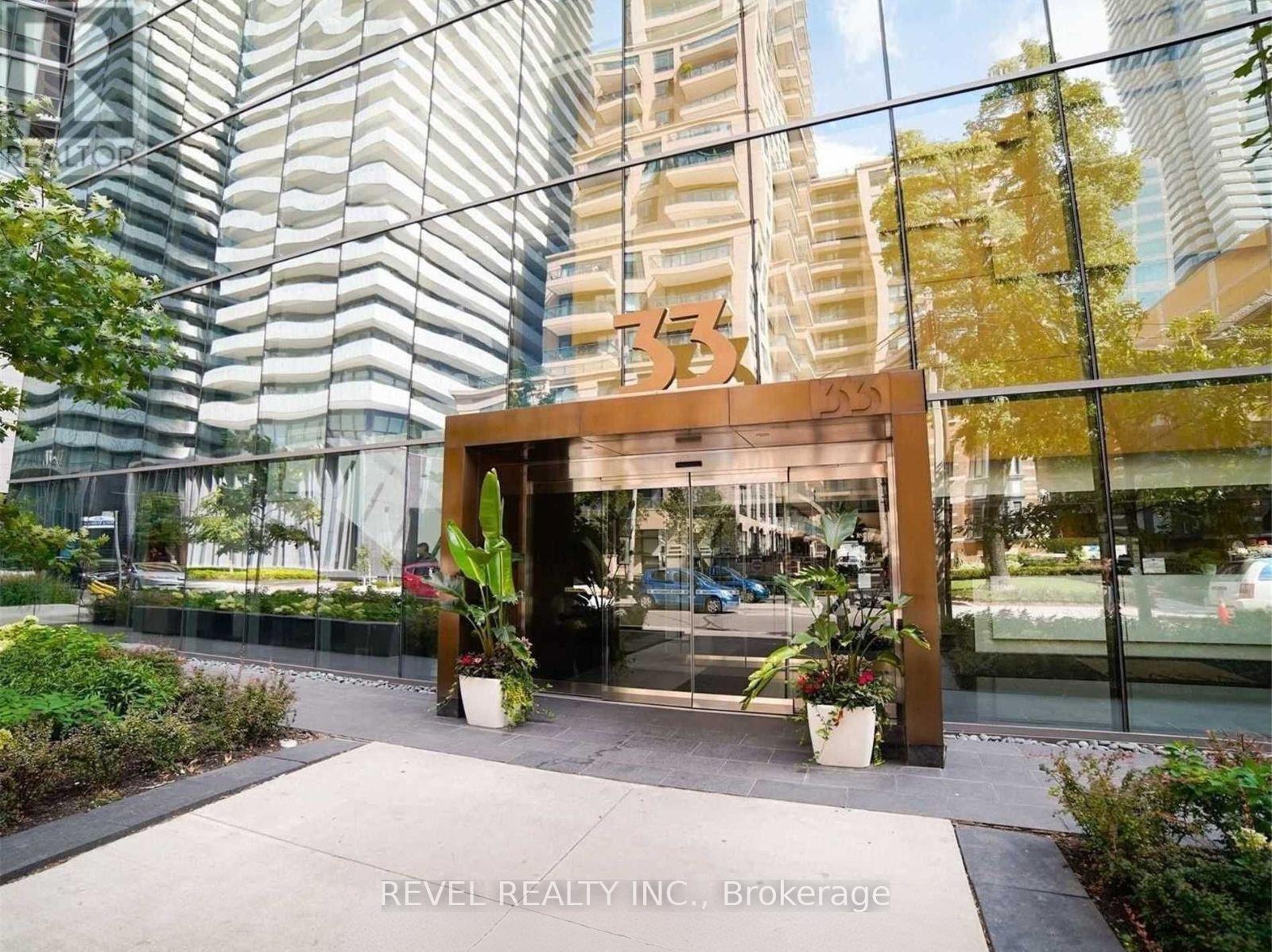 The entrance to a building with a glass facade and a wooden archway.