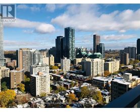 A cityscape with a mix of modern and older buildings under a partly cloudy sky.