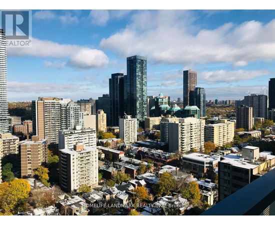 A cityscape with a mix of modern and older buildings under a partly cloudy sky.