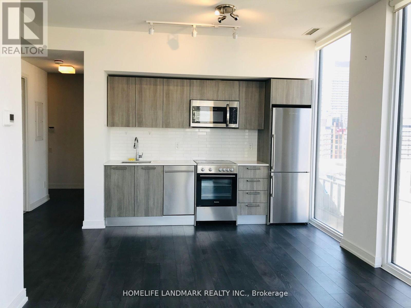 A kitchen with a stainless steel refrigerator, oven, and microwave.