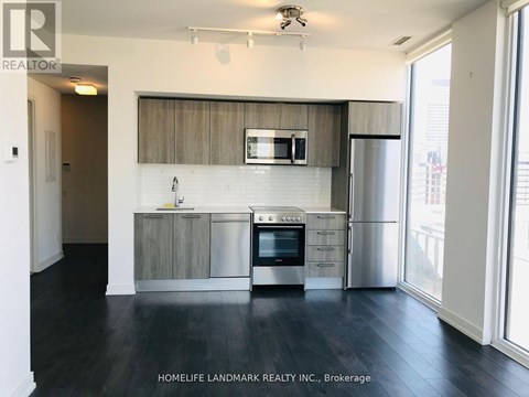 A kitchen with a stainless steel refrigerator, oven, and microwave.