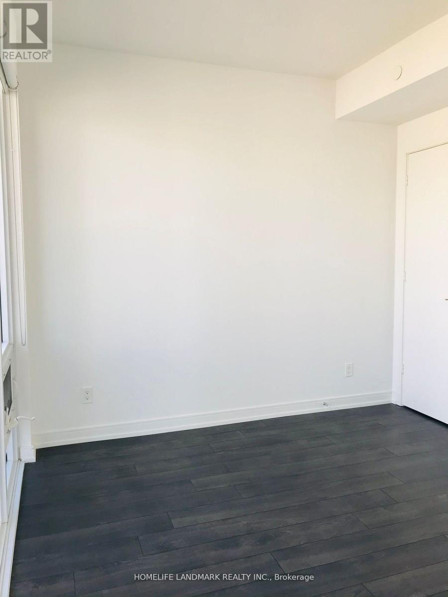 A room with white walls and dark wood flooring.