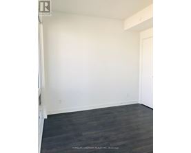 A room with white walls and dark wood flooring.