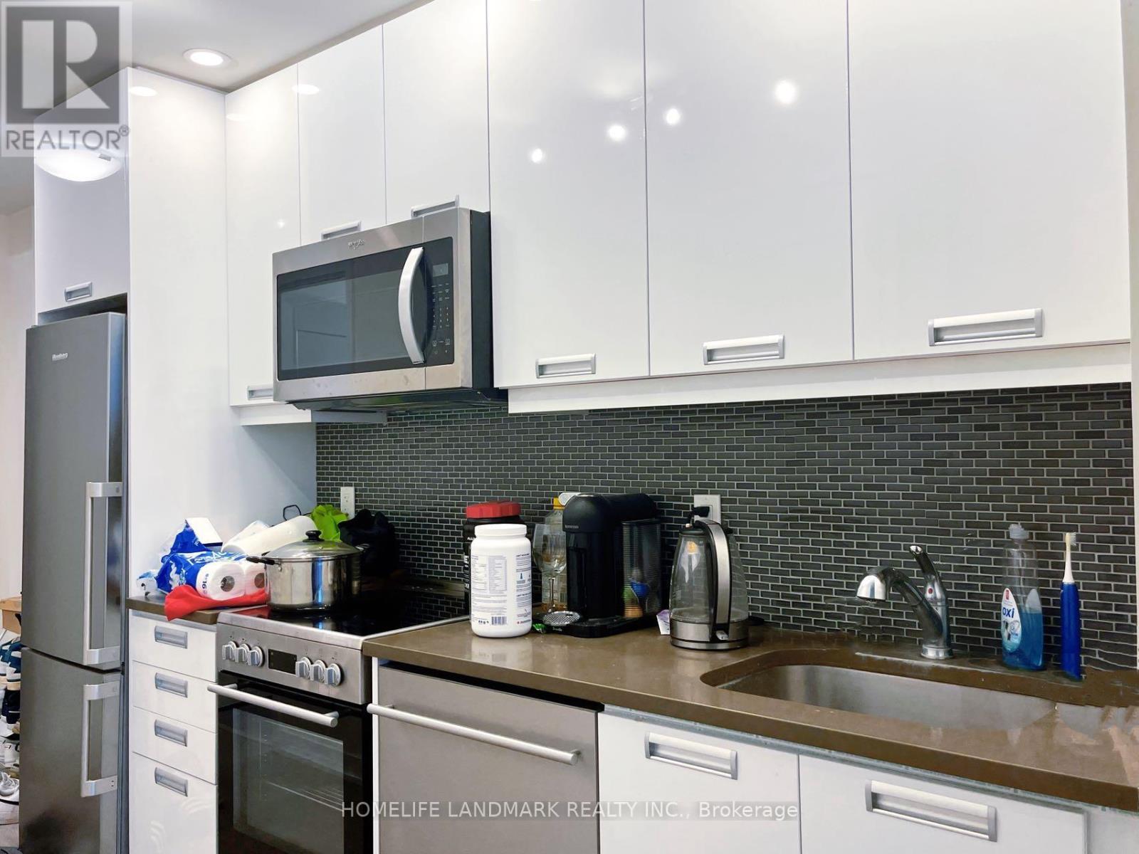A kitchen with a stove, oven, microwave, and sink.