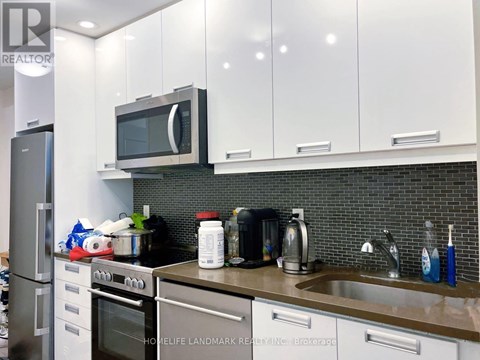 A kitchen with a stove, oven, microwave, and sink.
