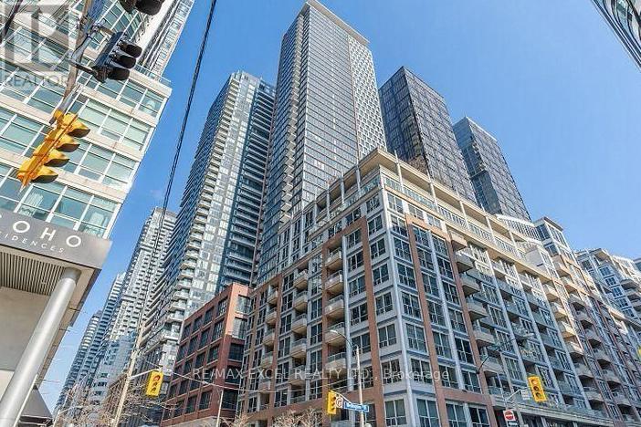 A tall building with many windows is in the foreground of the image.