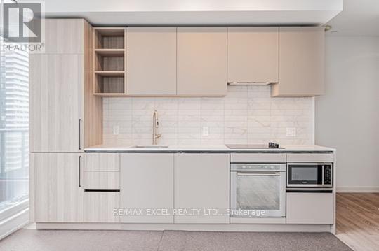 A kitchen with white cabinets and a white tiled backsplash.