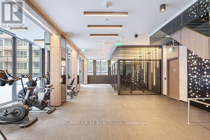 A gym with exercise equipment and a sign that says RE/MAX EXCEL REALTY LTD.