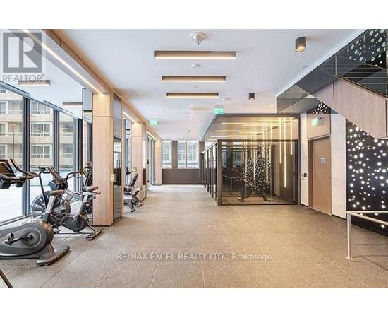 A gym with exercise equipment and a sign that says RE/MAX EXCEL REALTY LTD.