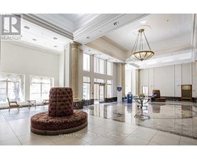 A large, elegant room with a round table and chairs in the center.
