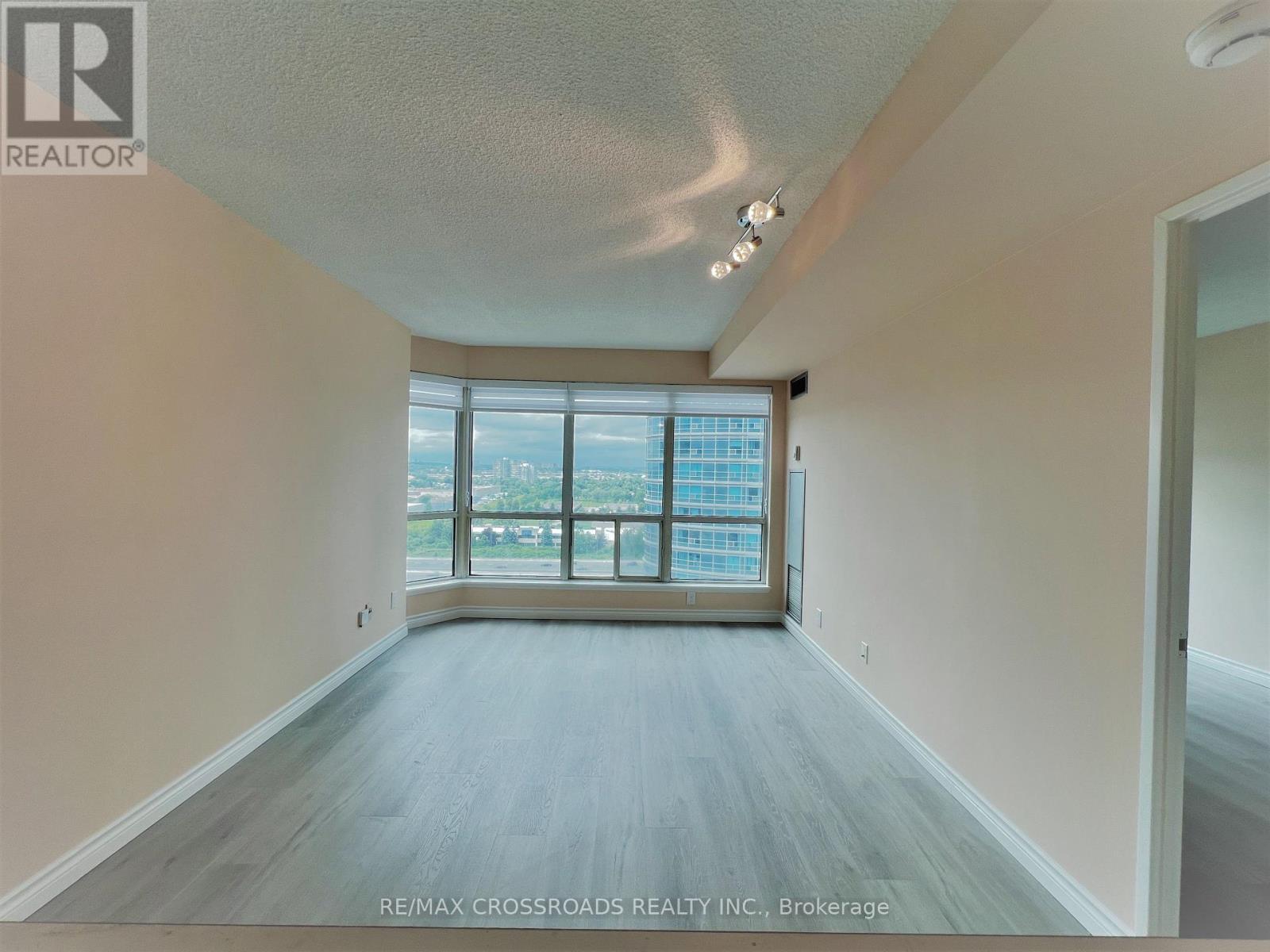 A spacious room with a large window overlooking a cityscape.