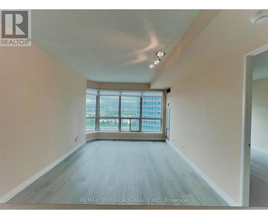 A spacious room with a large window overlooking a cityscape.
