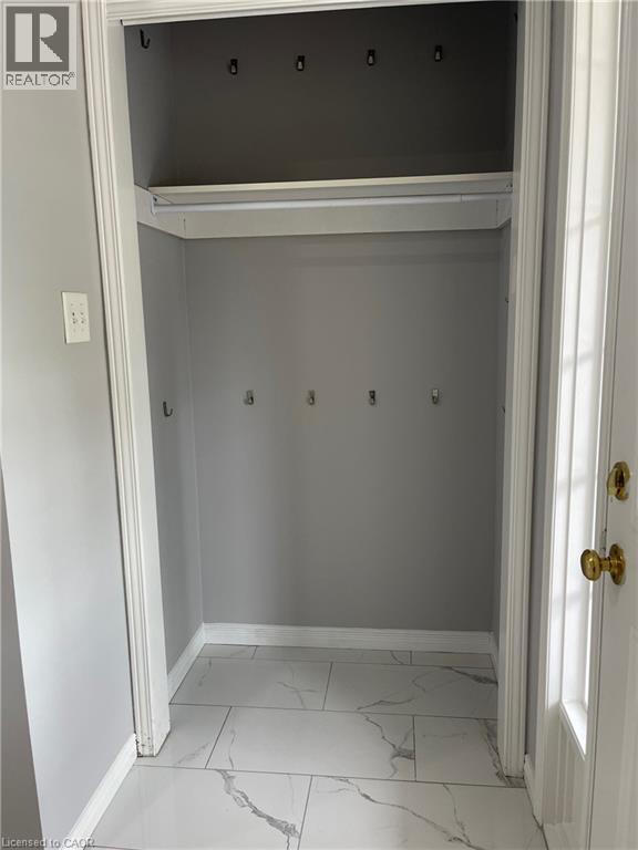 A white doorway with a gold door handle and a Realtor logo on the top left.