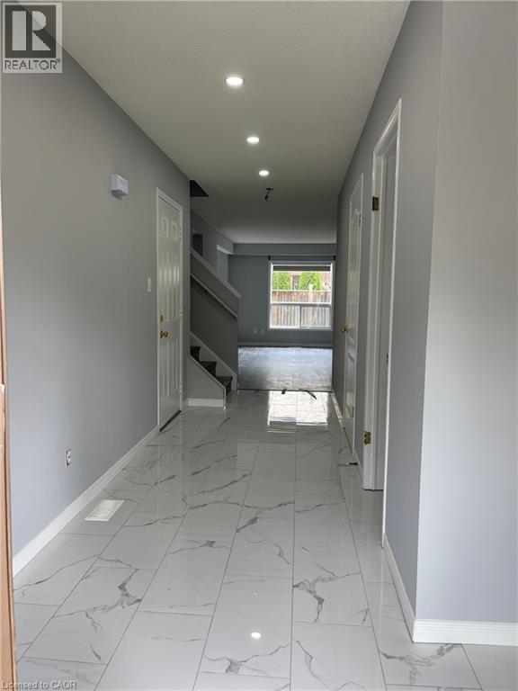 A long hallway with marble floors and white walls.
