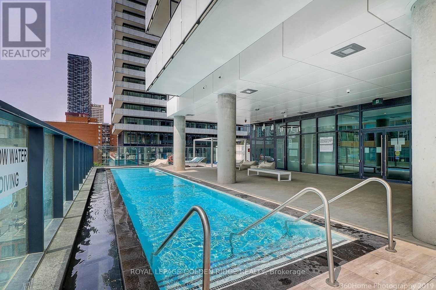 A swimming pool in a building with a glass wall.