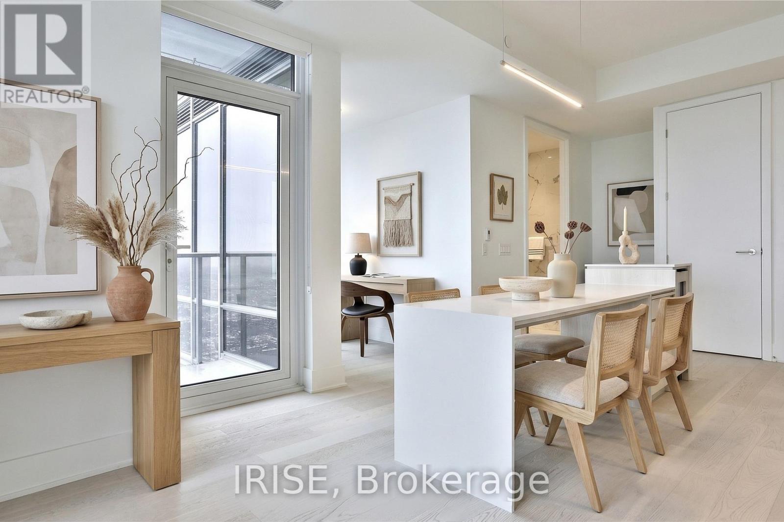 A dining room with a table set for two and a vase on the table.