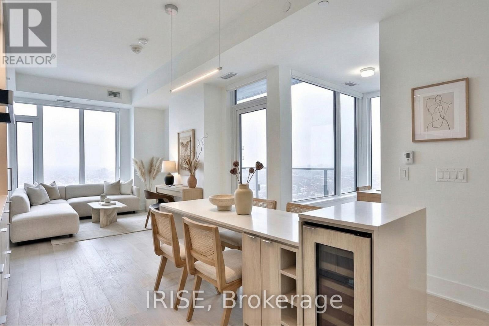 A modern kitchen with wooden chairs and a dining table.