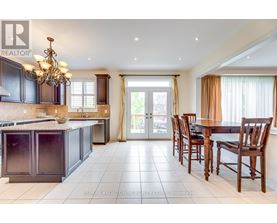 A large, well-lit kitchen with dark wood cabinets and a chandelier.
