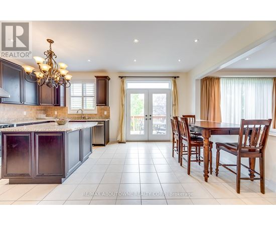A large, well-lit kitchen with dark wood cabinets and a chandelier.