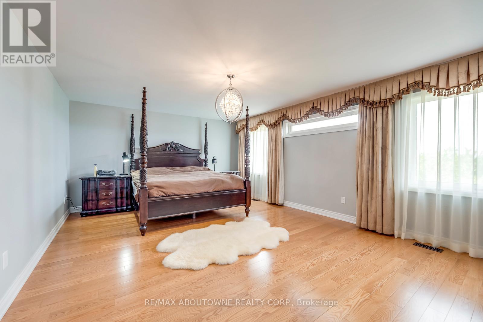 A bedroom with a four poster bed and a white furry rug.
