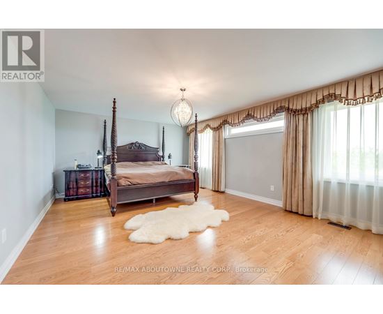 A bedroom with a four poster bed and a white furry rug.