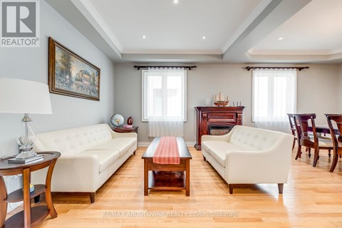 A living room with a white sofa, a wooden coffee table, and a painting on the wall.