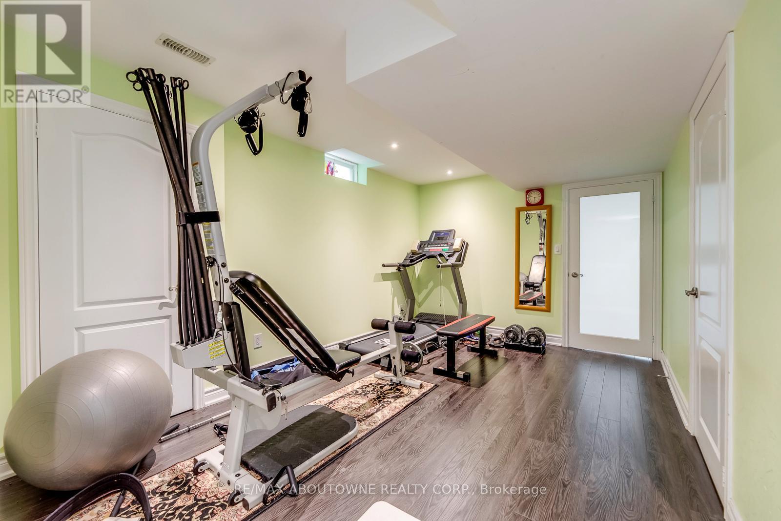 A home gym with a variety of equipment including a treadmill, rowing machine, and weights.