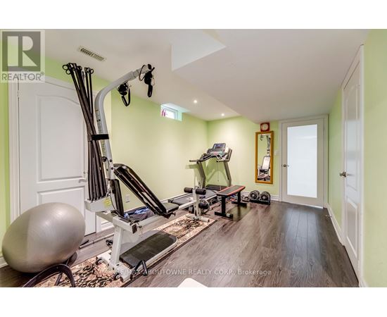 A home gym with a variety of equipment including a treadmill, rowing machine, and weights.