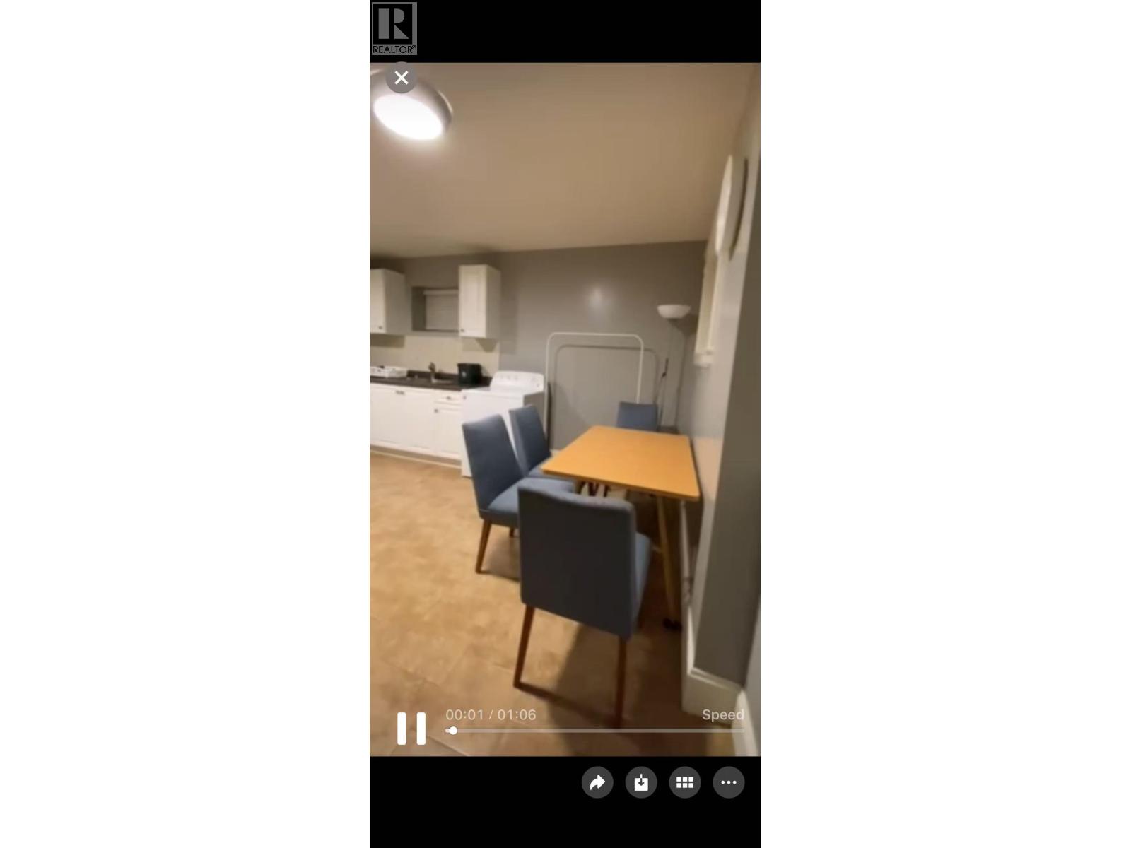 A kitchen with a table and chairs.