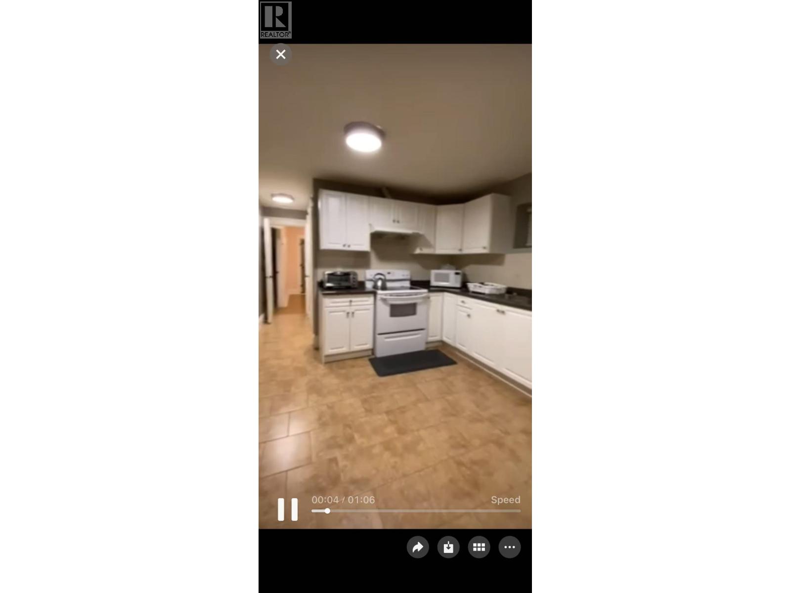 A kitchen with white cabinets and a wooden floor.