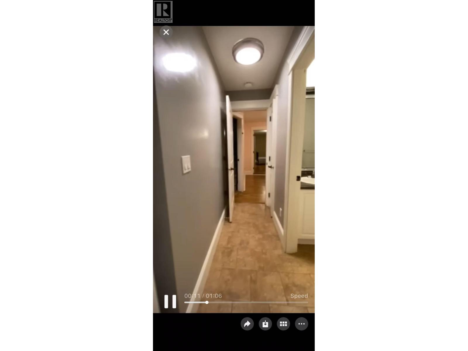 A video player with a paused video showing a hallway.