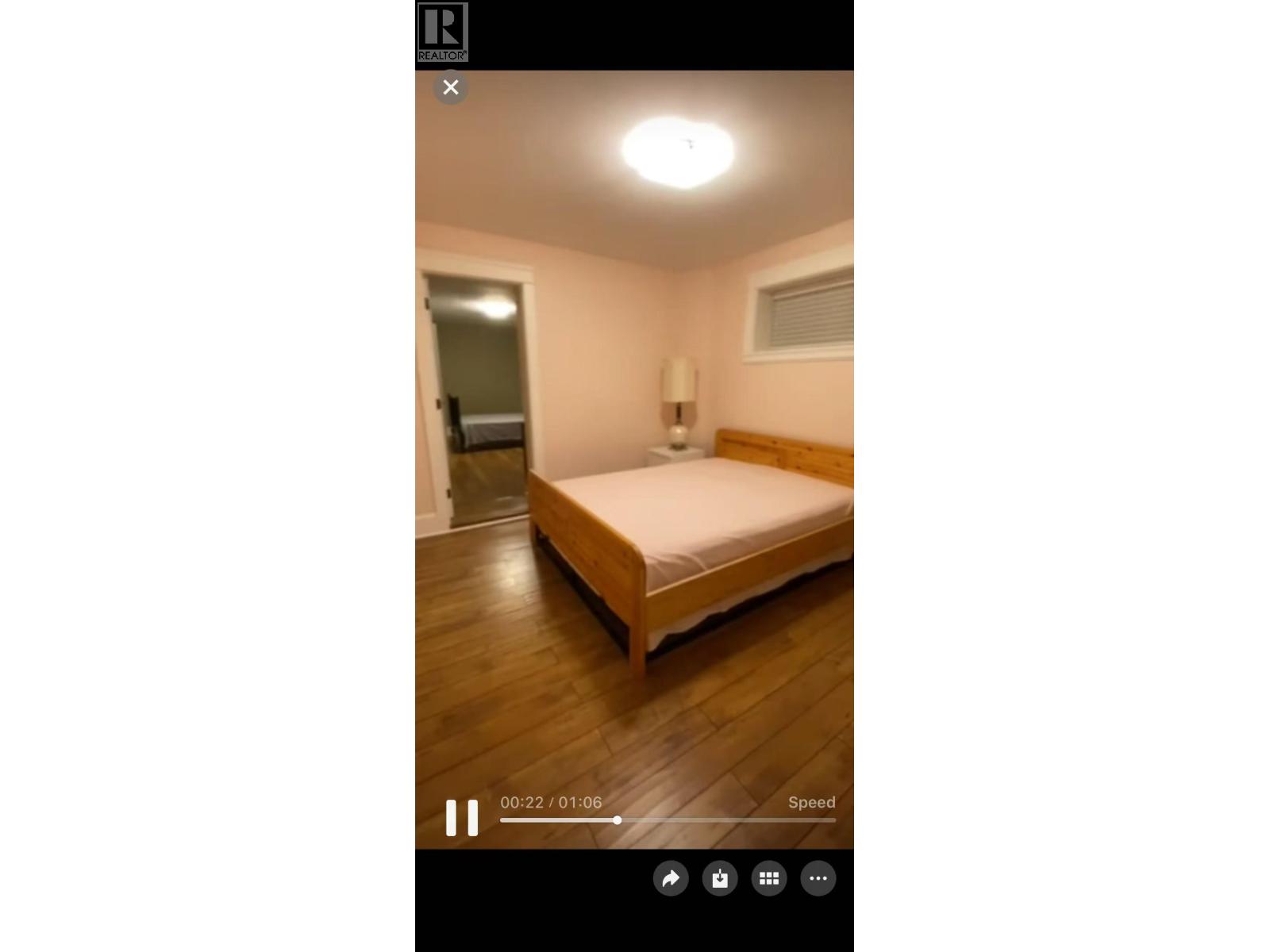 A bedroom with a bed, a lamp, and a door.