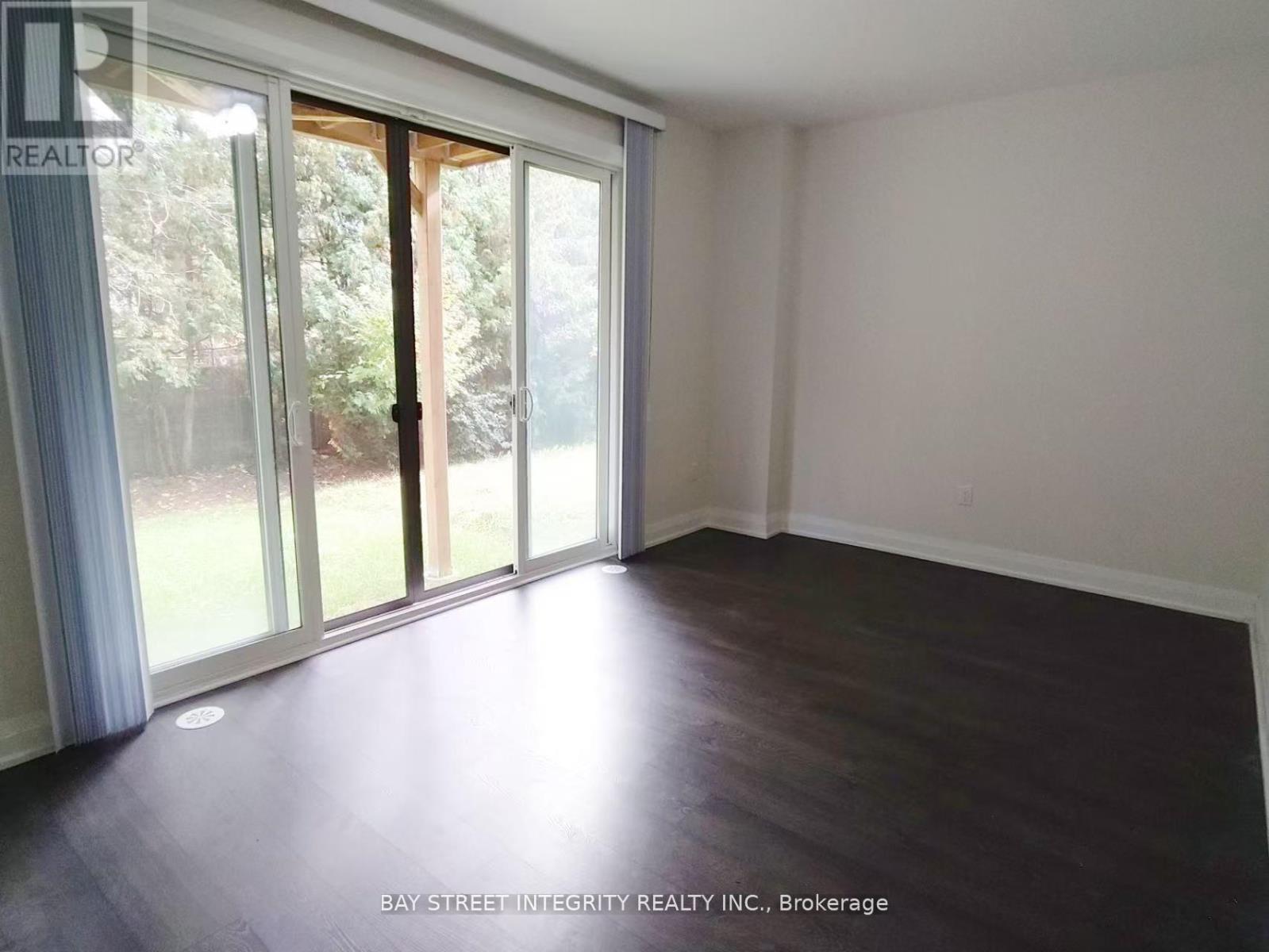 A room with a sliding glass door leading to a backyard.