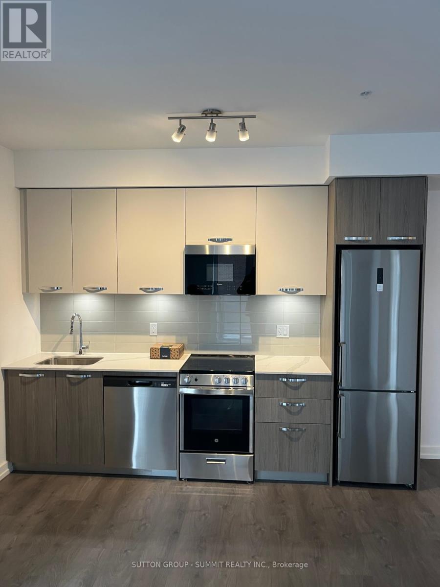 A modern kitchen with stainless steel appliances and wooden cabinets.