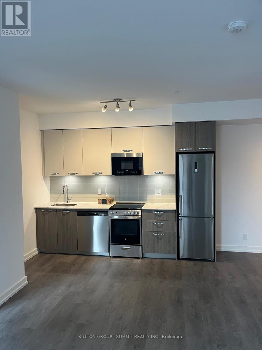 A modern kitchen with stainless steel appliances and wooden cabinets.