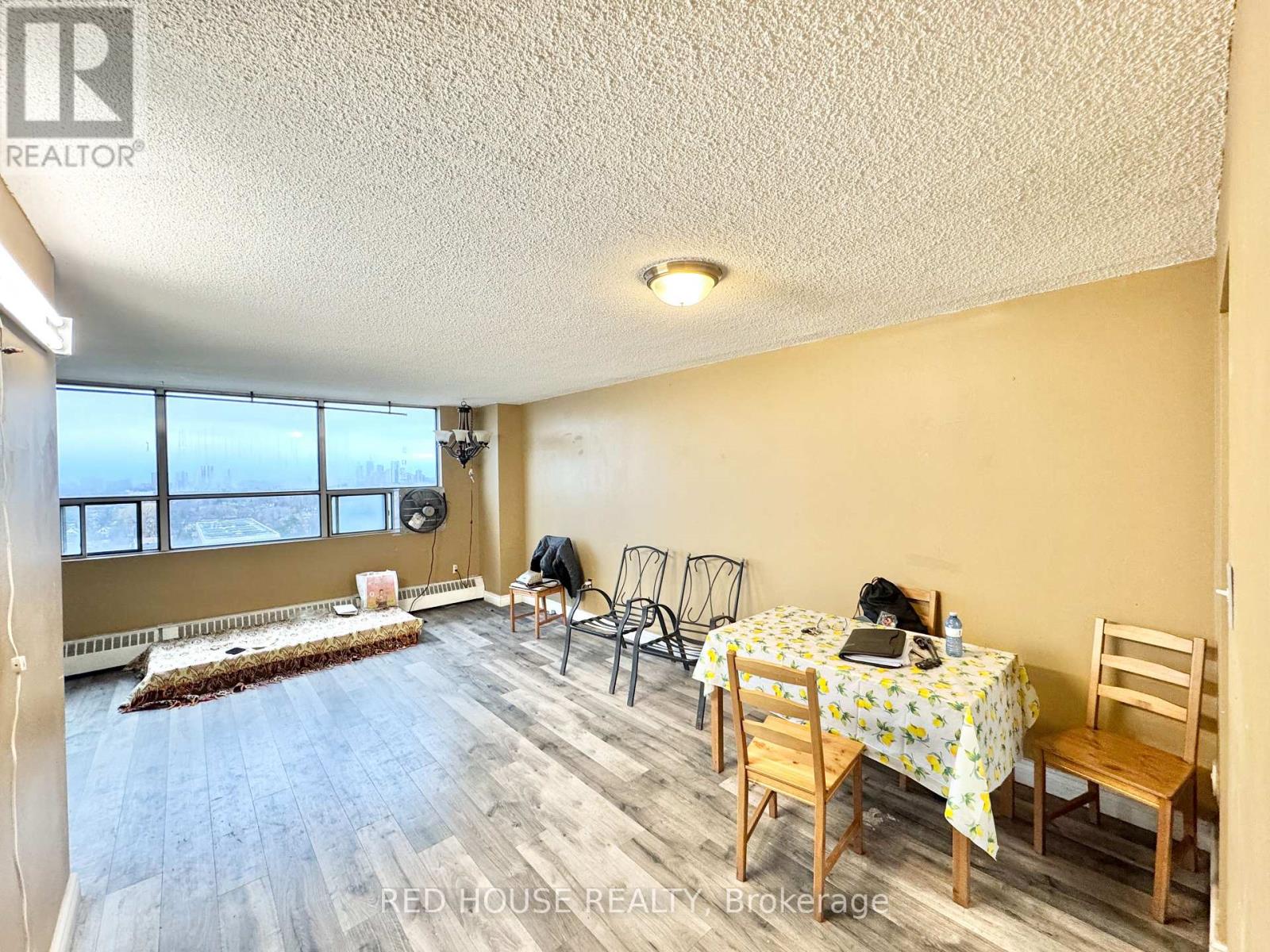 A dining room with a table set for two and chairs around it.